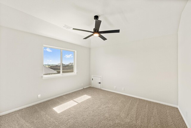 empty room with carpet floors, baseboards, ceiling fan, and visible vents