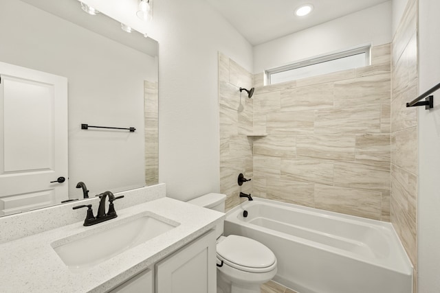 full bathroom featuring toilet, tiled shower / bath combo, and vanity