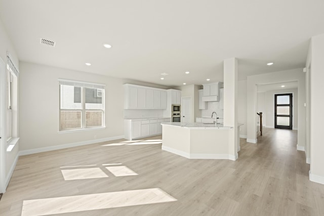kitchen featuring visible vents, light wood-style floors, white cabinets, and stainless steel appliances