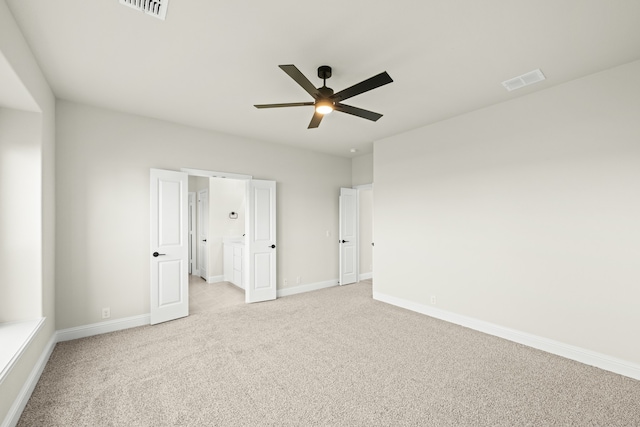 carpeted spare room with ceiling fan