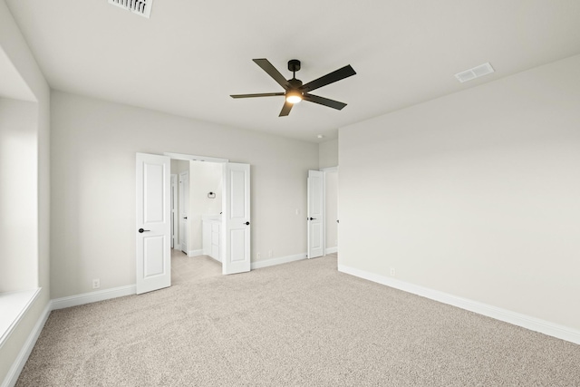 unfurnished bedroom featuring baseboards, light colored carpet, and visible vents