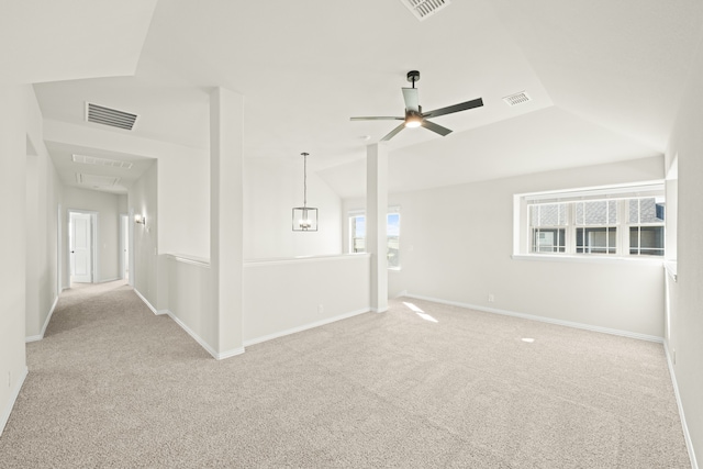 unfurnished room with lofted ceiling, light carpet, and plenty of natural light