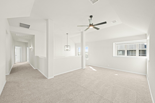unfurnished room with carpet floors, a ceiling fan, visible vents, and a healthy amount of sunlight