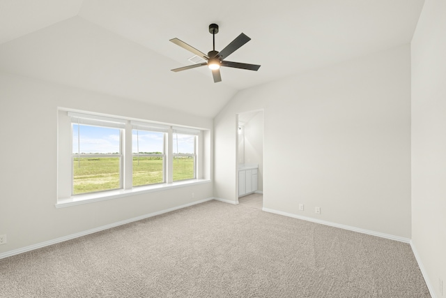 unfurnished room featuring light carpet, vaulted ceiling, and ceiling fan