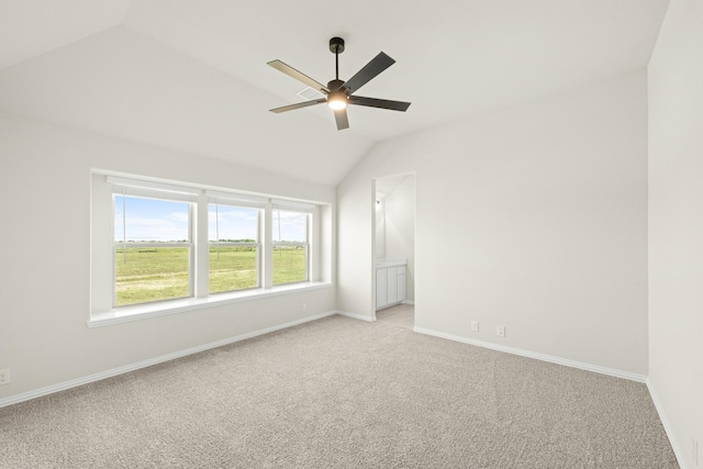 spare room featuring a ceiling fan, baseboards, light colored carpet, and lofted ceiling