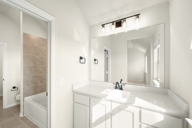 bathroom featuring toilet, lofted ceiling, a bathing tub, vanity, and tile patterned flooring