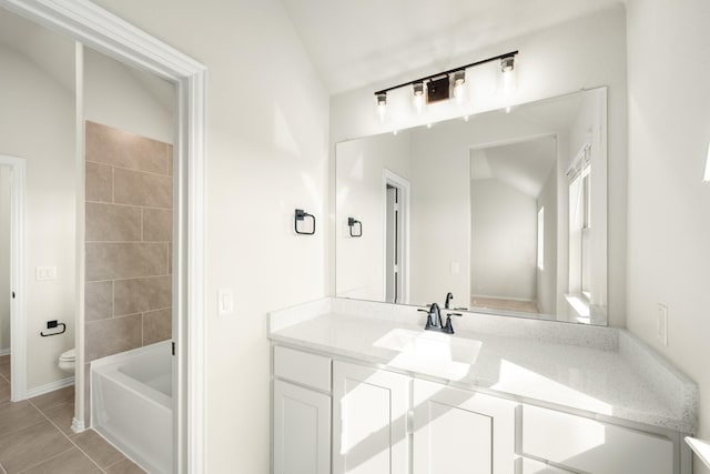 bathroom with a bath, tile patterned floors, baseboards, vanity, and toilet
