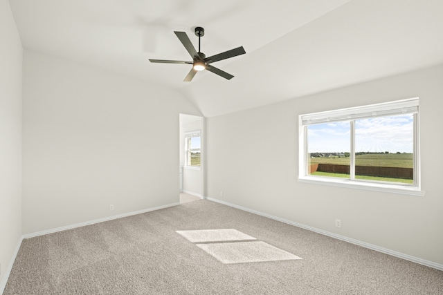 empty room featuring lofted ceiling, carpet floors, and ceiling fan