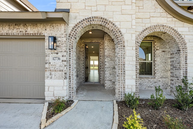 property entrance with a garage and brick siding