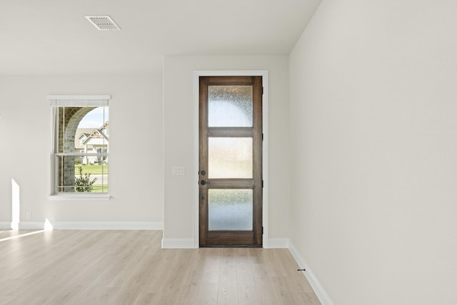 entrance foyer with baseboards, visible vents, a wealth of natural light, and light wood-style floors