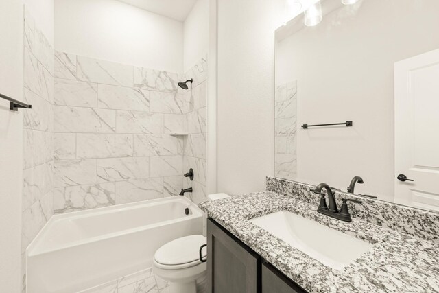 full bathroom featuring vanity, tiled shower / bath, and toilet