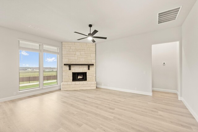 unfurnished living room featuring ceiling fan, a fireplace, and light hardwood / wood-style flooring