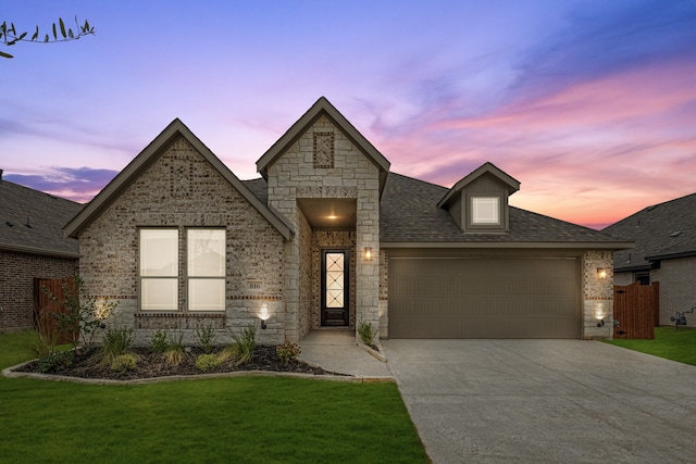 view of front of home featuring a garage and a yard