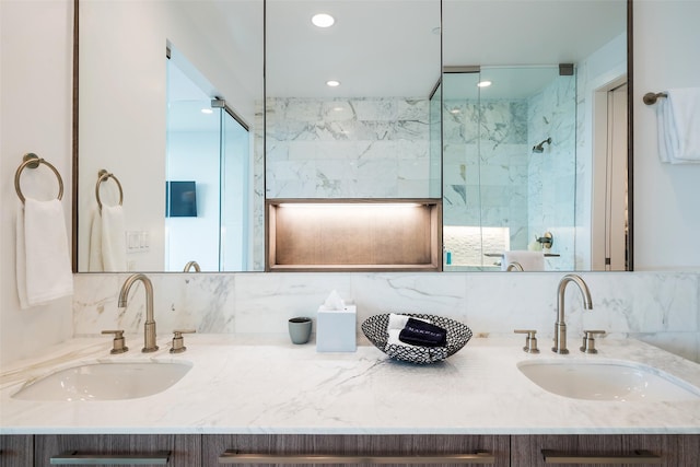 bathroom featuring decorative backsplash, a shower with door, and vanity