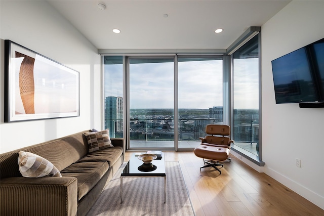 living room with plenty of natural light, expansive windows, and hardwood / wood-style floors