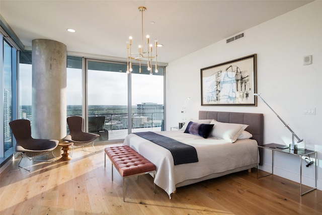 bedroom featuring multiple windows, hardwood / wood-style floors, and a wall of windows