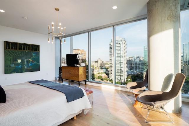 bedroom featuring a chandelier, light hardwood / wood-style flooring, and expansive windows