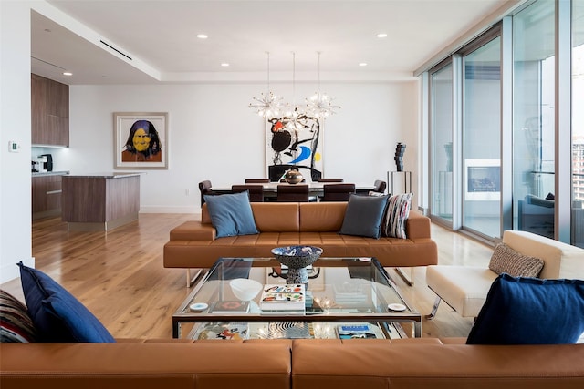 living room featuring a wall of windows, plenty of natural light, light hardwood / wood-style floors, and a notable chandelier