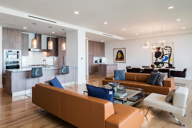 living room with light hardwood / wood-style flooring and a chandelier