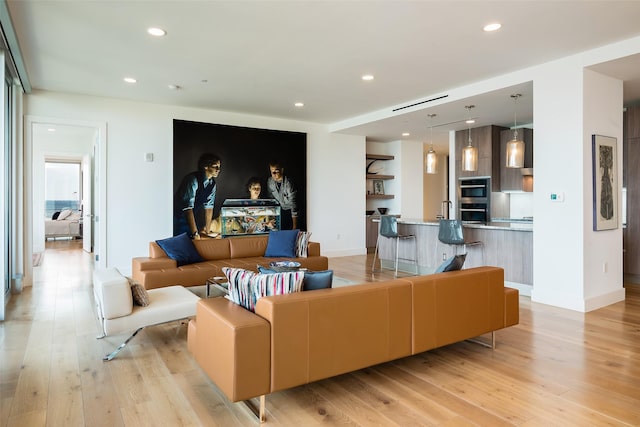 living room with light hardwood / wood-style floors and sink