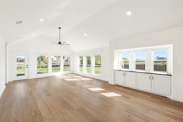 unfurnished sunroom featuring ceiling fan, plenty of natural light, and vaulted ceiling