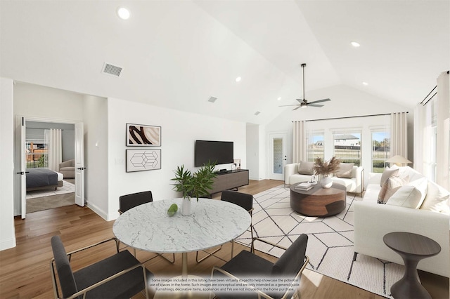 living room featuring ceiling fan, light hardwood / wood-style floors, and vaulted ceiling