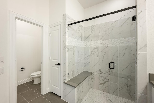 bathroom featuring tile patterned flooring, toilet, and an enclosed shower