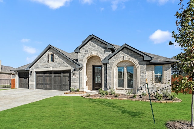 french country home featuring a garage and a front yard