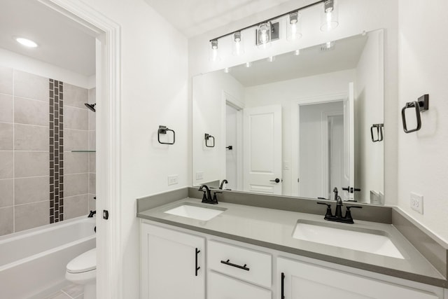 full bathroom with vanity, tiled shower / bath combo, and toilet