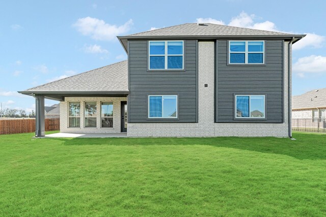 rear view of property with a yard and a patio