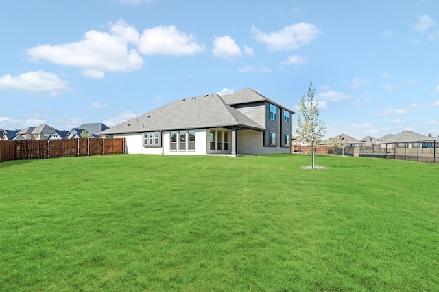 rear view of house featuring a yard