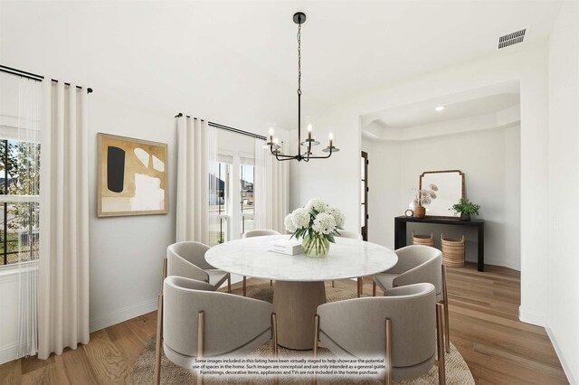 dining room with a healthy amount of sunlight, a chandelier, and hardwood / wood-style flooring