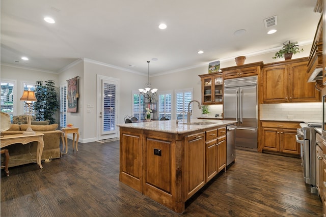 kitchen featuring sink, an inviting chandelier, an island with sink, decorative light fixtures, and high quality appliances