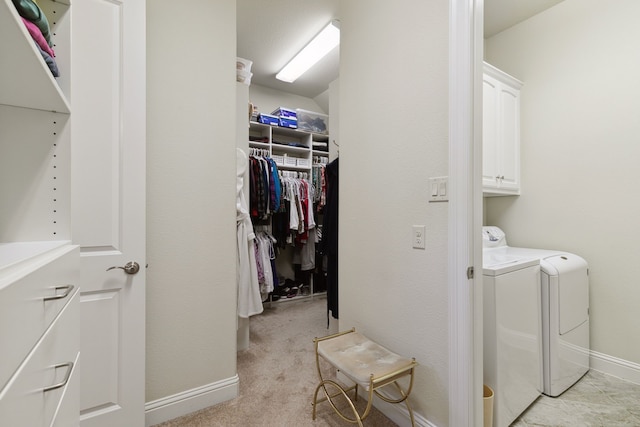 washroom with cabinets, light carpet, and separate washer and dryer