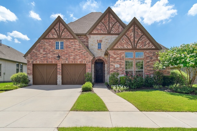 english style home featuring a front lawn and a garage