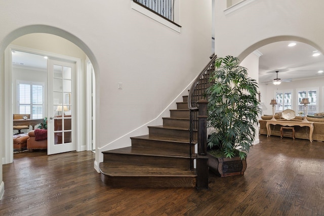 staircase featuring crown molding, ceiling fan, french doors, and wood-type flooring