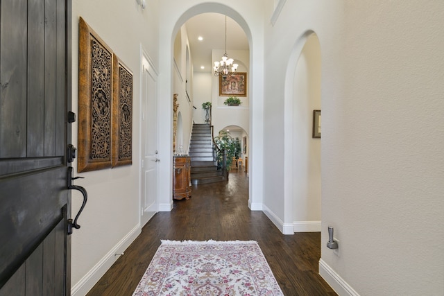 foyer featuring dark wood-type flooring, a high ceiling, and a chandelier