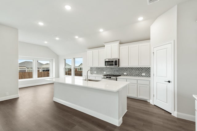 kitchen with stainless steel appliances, white cabinetry, and dark hardwood / wood-style flooring