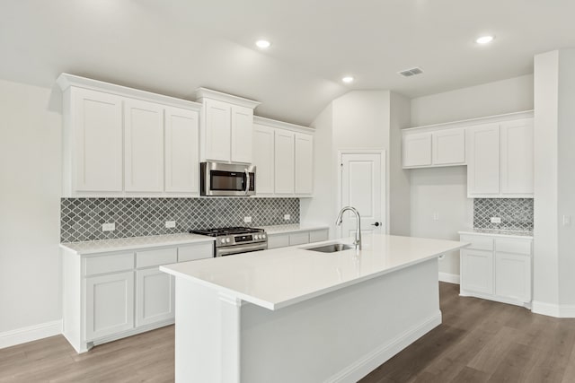 kitchen with stainless steel appliances, white cabinets, light wood-type flooring, and sink