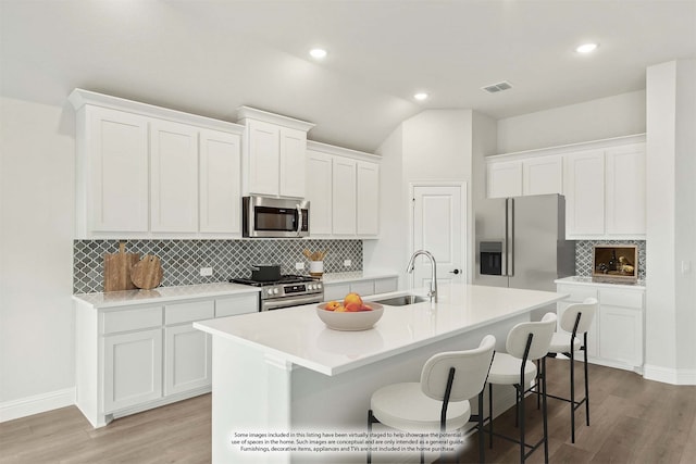 kitchen featuring an island with sink, appliances with stainless steel finishes, sink, and white cabinetry