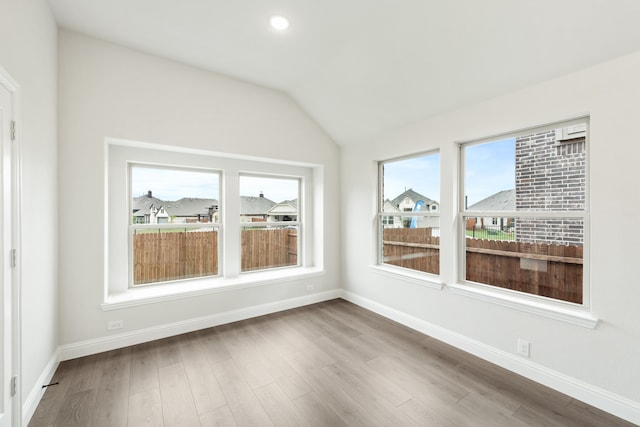 unfurnished sunroom featuring vaulted ceiling and a healthy amount of sunlight