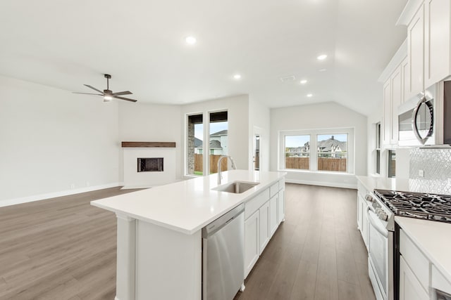 kitchen with white cabinetry, an island with sink, stainless steel appliances, wood-type flooring, and sink