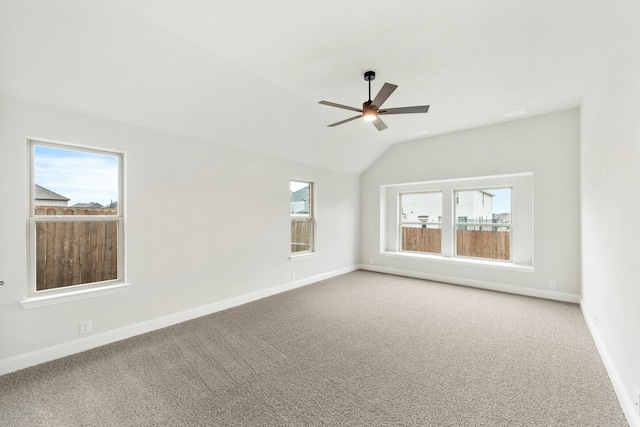 spare room featuring carpet, vaulted ceiling, ceiling fan, and a wealth of natural light