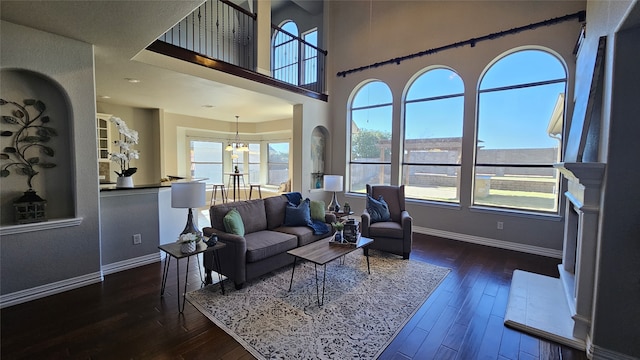 living room with dark hardwood / wood-style floors and an inviting chandelier