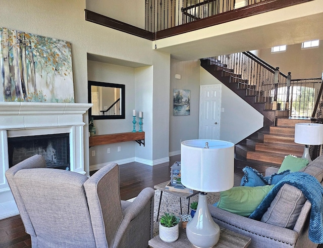 living room with dark hardwood / wood-style floors and a towering ceiling