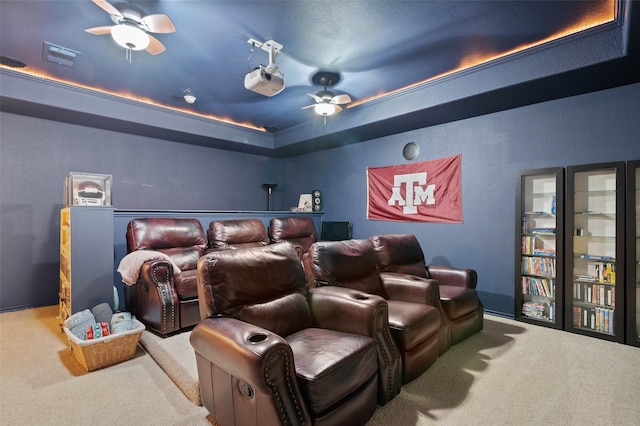 carpeted home theater room with a raised ceiling