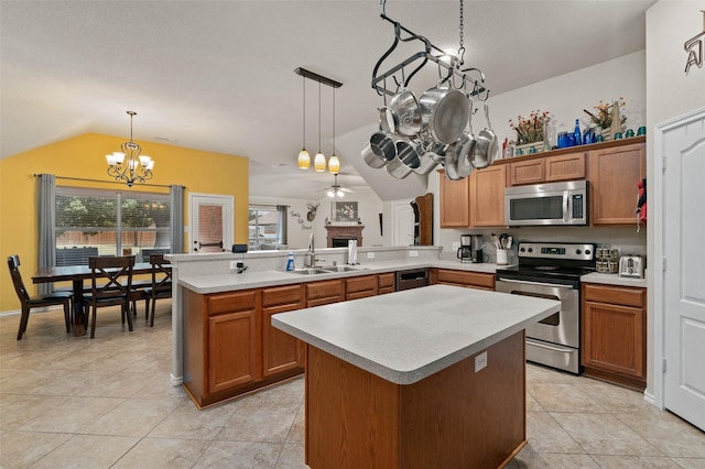 kitchen with pendant lighting, kitchen peninsula, sink, and stainless steel appliances