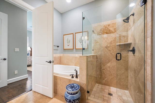 bathroom with hardwood / wood-style floors, crown molding, and separate shower and tub