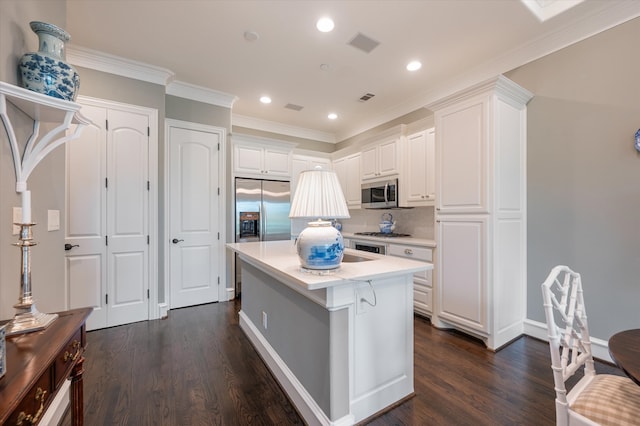 kitchen featuring a center island, white cabinetry, stainless steel appliances, backsplash, and dark hardwood / wood-style floors