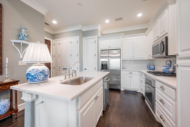 kitchen featuring sink, white cabinetry, appliances with stainless steel finishes, and an island with sink